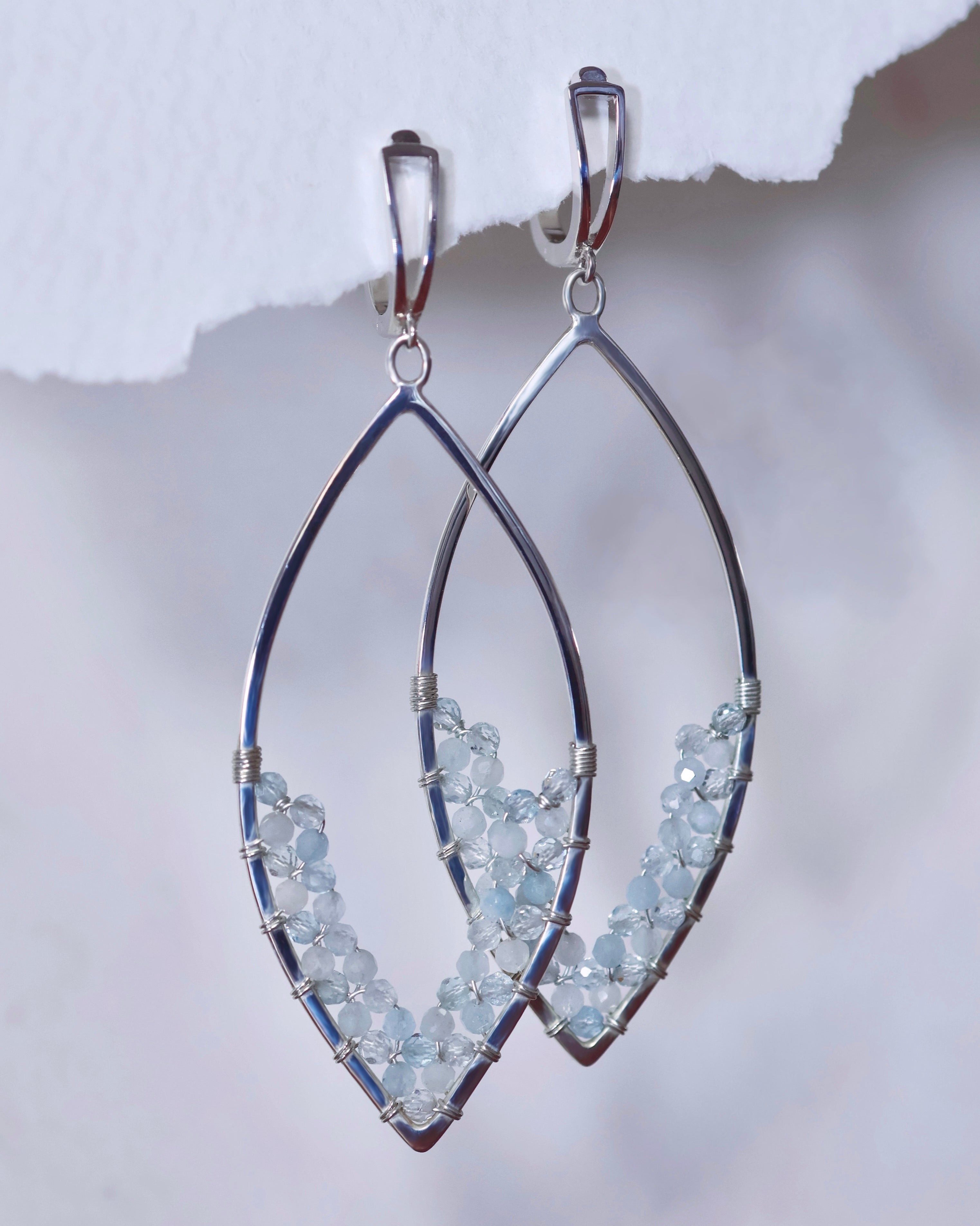 Aquamarine Earrings by Lilac Sky Studio: Sterling Silver marquise-shaped earrings featuring small aquamarine gemstone beads on the lower curve, finished with secure lever-back ear wires.