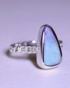 The Boulder Opal Ring by Lilac Sky Studio features a chain-link sterling silver band and a large, uniquely shaped boulder opal gemstone in a smooth bezel, offering subtle coastal charm.