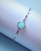 The Lilac Sky Studio Cloud Mountain Turquoise Bracelet No. 3 features a round turquoise centerpiece set in sterling silver with an adjustable cable chain, displayed on a soft, light surface.