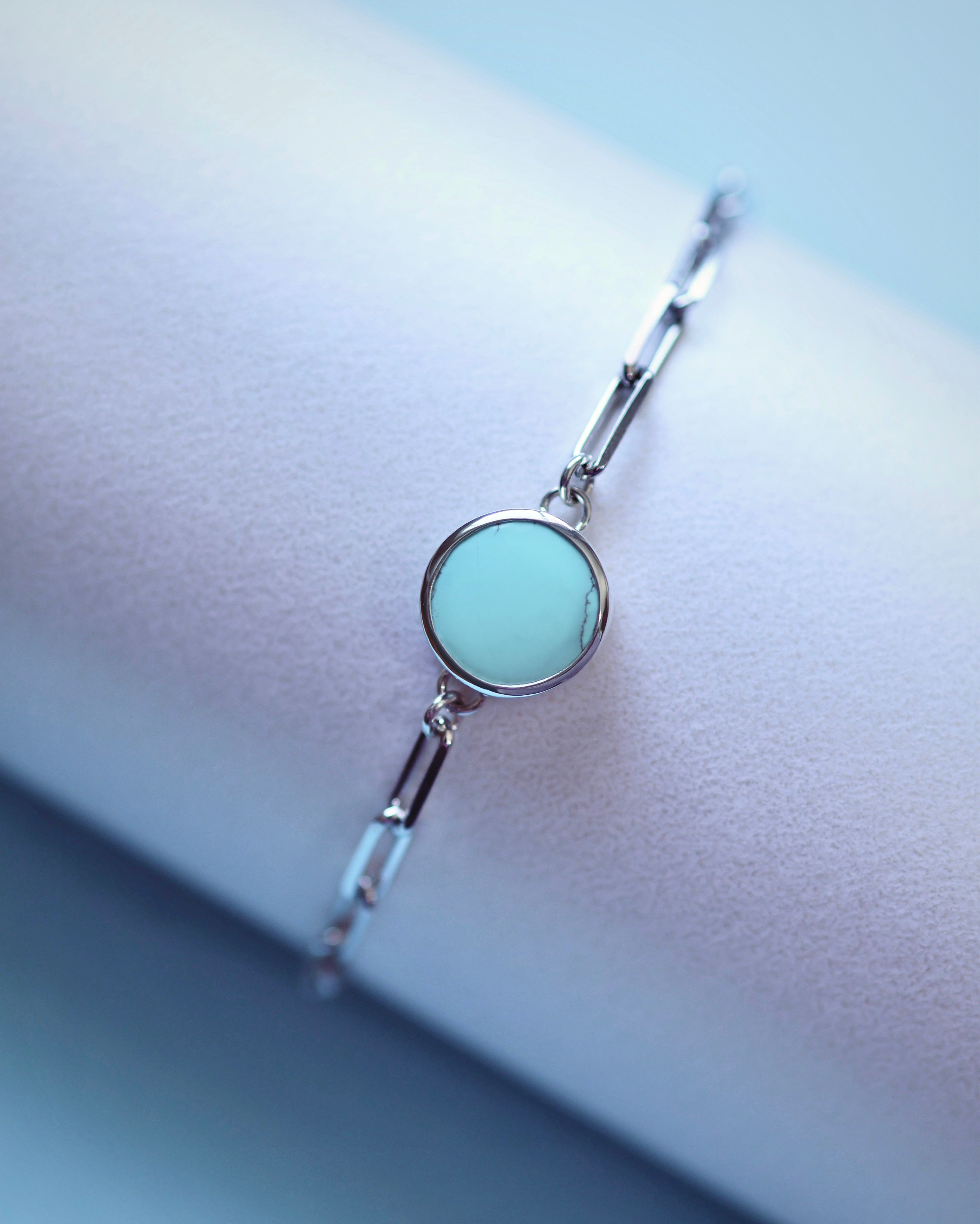 The Lilac Sky Studio Cloud Mountain Turquoise Bracelet No. 3 features a round turquoise centerpiece set in sterling silver with an adjustable cable chain, displayed on a soft, light surface.