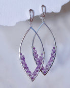 Amethyst Earrings by Lilac Sky Studio feature sterling silver marquise shapes with handwoven amethyst beads along the lower half, displayed on a light background.